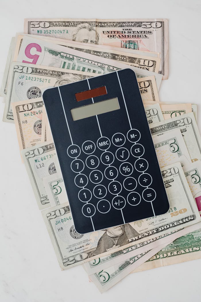 A calculator placed on US dollar banknotes, symbolizing financial planning and money management.